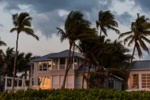 Florida house on the coast with storm weather and wind blowing palm trees